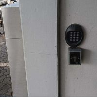 Ein Gehäuse mit Tastatur zur Eingabe von Ziffern ist an einer Mauer befestigt.